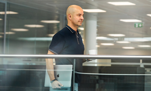 Roberto 拿著他的筆記型電腦在走路。