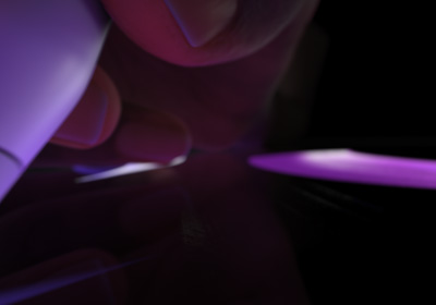  Naudotojo ranka, laikanti „Apple Pencil Pro“ rašymo padėtyje. Galiukas spaudžiamas ant ekrano, brėžiamos ryškiai žalios storos linijos.