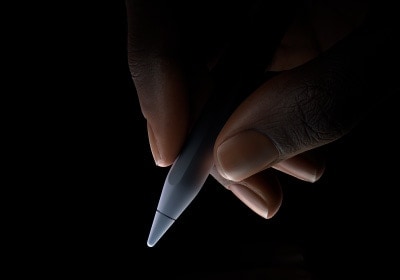 Une personne tient la partie inférieure d’un Apple Pencil Pro entre le pouce et l’index, comme pour écrire.