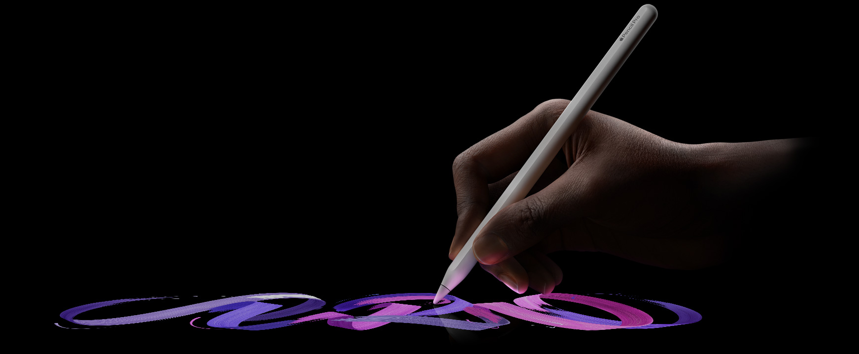 Une main trace une ligne de couleur vive avec l’Apple Pencil Pro.
