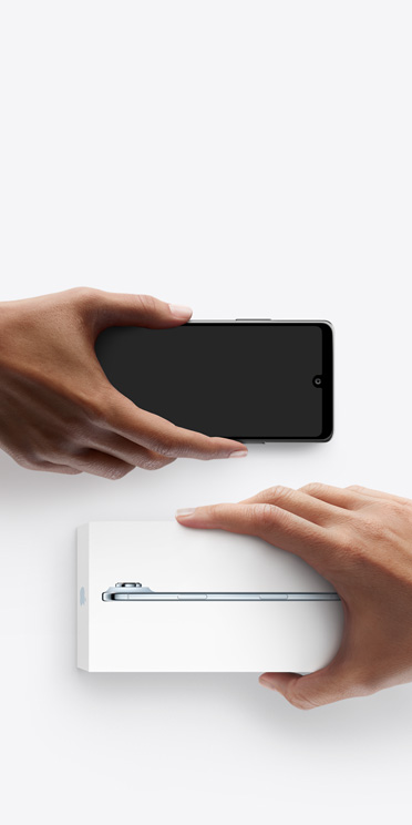 Käed, mis vahetavad telefone, Android vasakul ilma karbita, paremal on uus iPhone Air karbis