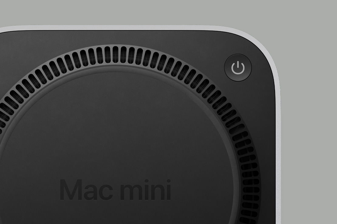 Mac mini 的黑色底部，展示電源按鈕和環形風扇式通風架構